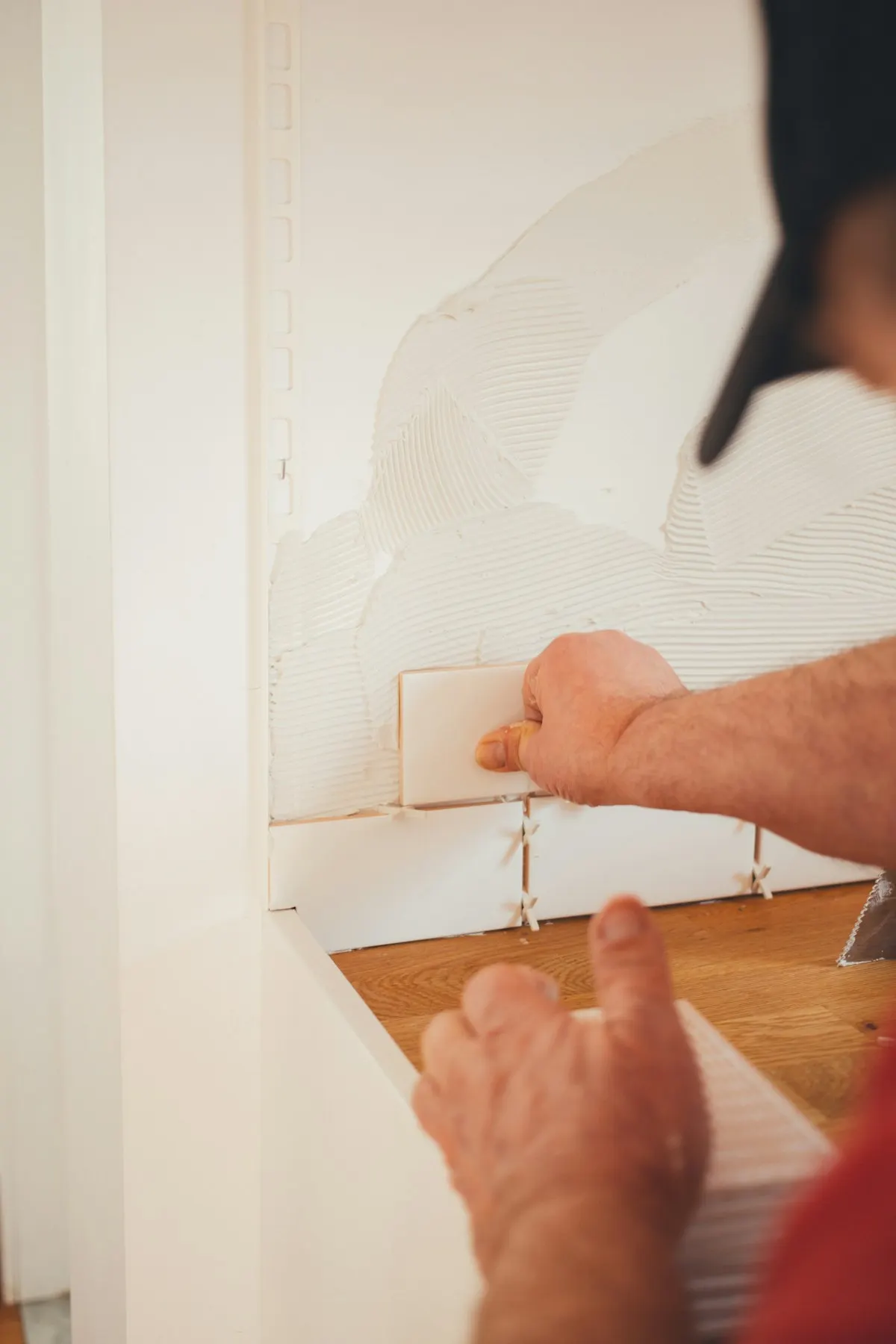 Person applying finish along an interior wall edge