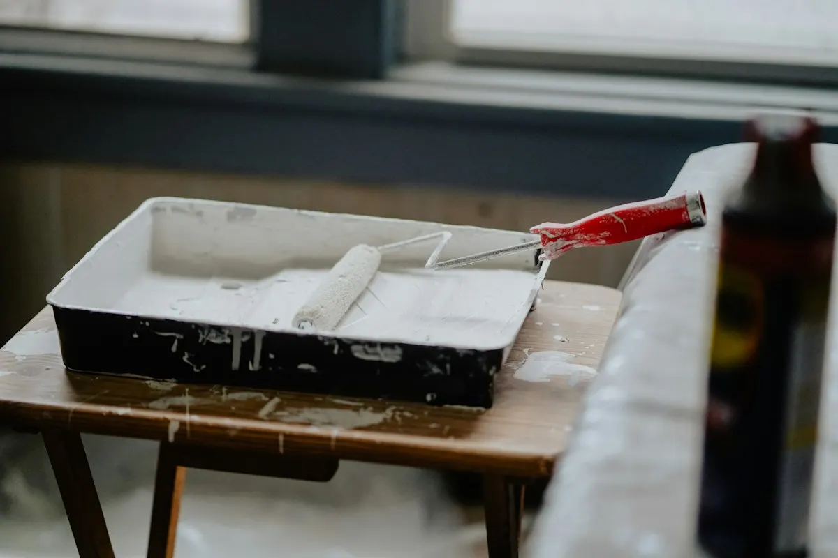 Paint tray and roller on a timber work surface