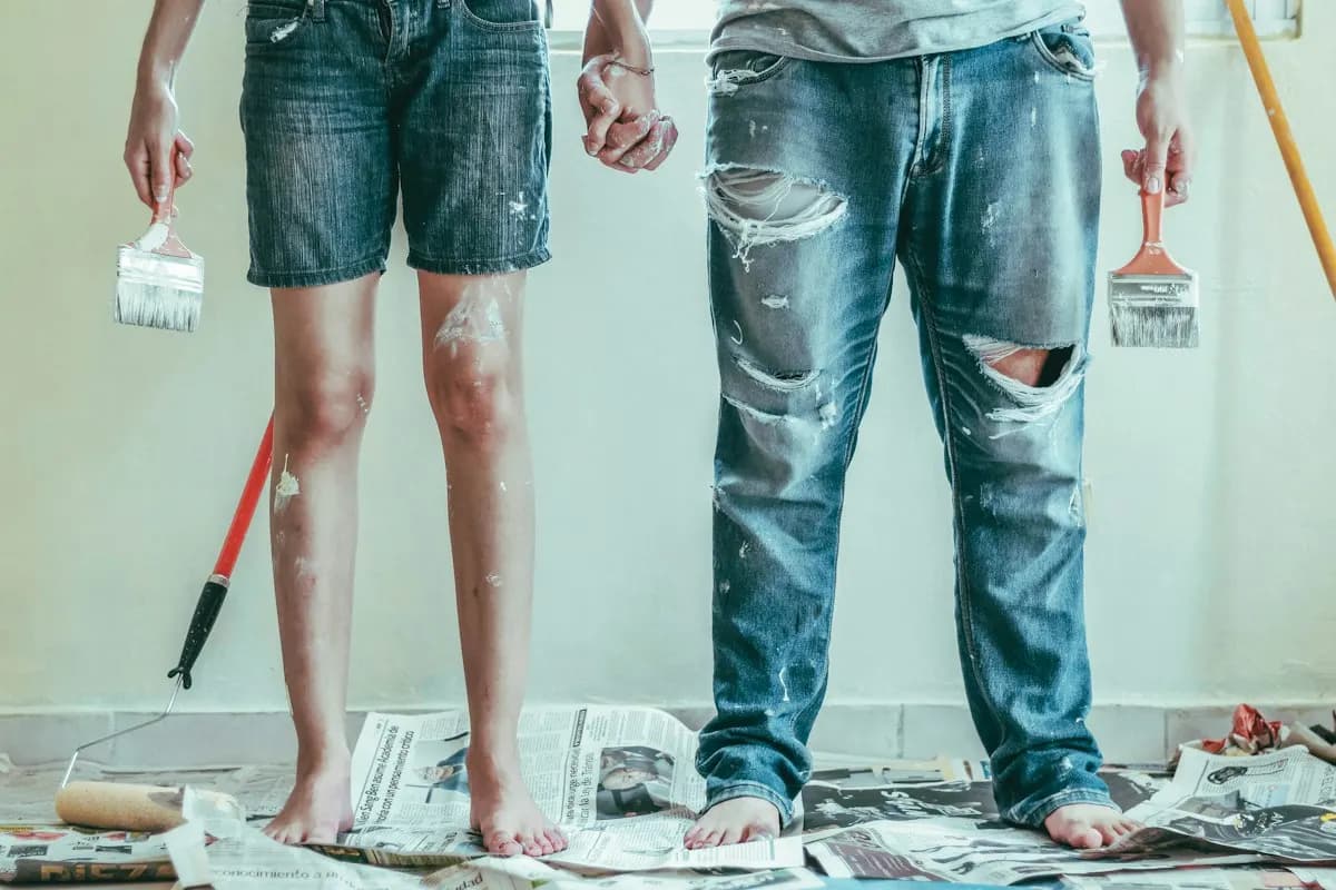 Two people holding paintbrushes during an interior renovation